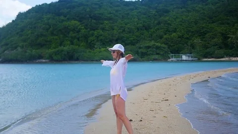 A young girl walks along the shore of the beach Stock Footage