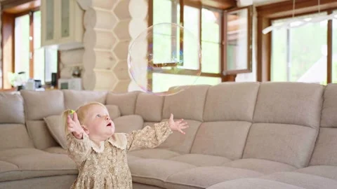 Young Girl Watching Bubble Float in Home Stock Footage 282507799