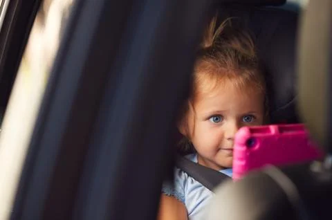 Young Girl Watching Digital Tablet In Back Seat On Car Journey Stock Photos