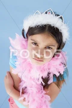 Young girl wearing crown and feather boa frowning Stock Photos