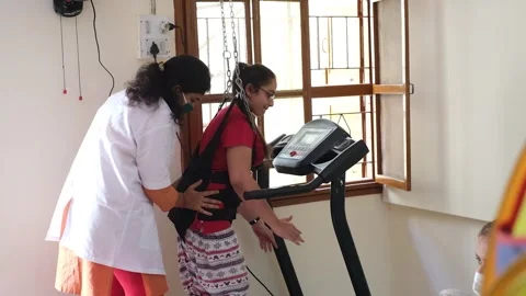 A young girl who cannot walk is being trained by a doctor to practice Stock Footage 247107301