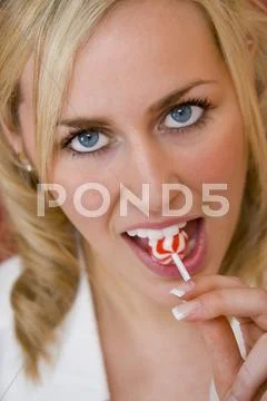 Young girl woman eating a sweet lollipop Stock Photos