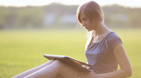 Young Girl Working On A Laptop While Sitting On A Green Lawn Stock Footage 52582471