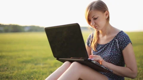 Young Girl Working On A Laptop While Sitting On A Green Lawn Stock Footage 52582607