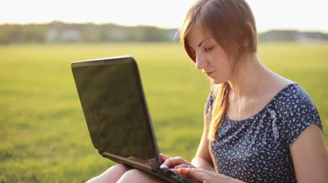 Young Girl Working On A Laptop While Sitting On A Green Lawn Stock Footage 52582924