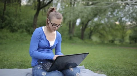 Young Girl Working On A Laptop While Sitting On The Lawn Video stock 62844918