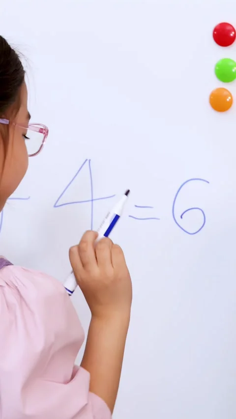 Young Girl Writing Math Problems on Whiteboard with Teacher Encouragement Stock Footage 330995506