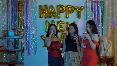 Young girlfriends talking and clinking wine/champagne glasses during New year... Stock Footage 121454029