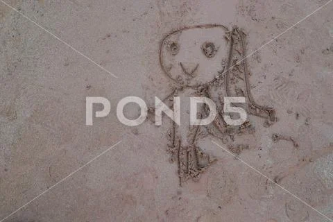 A young girl's classic hand drawing on the sandy beach Stock Photos