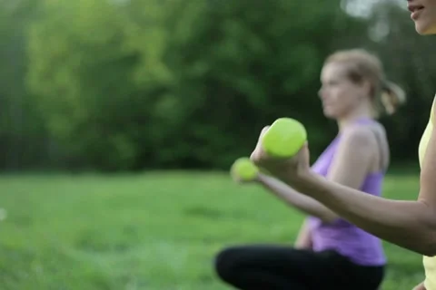 Young girls doing exercise with dumbbells outdoors, tracking shot NTSC Stock Footage 10962337