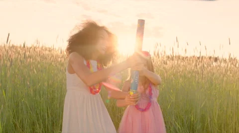 Young girls exploding party cracker in the wheat field and merrily catching the Stock Footage 64776382