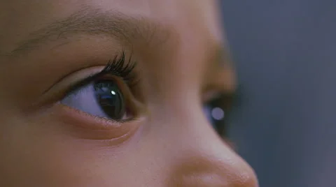 Young girls eyes moving about as she watches a screen Stock Footage