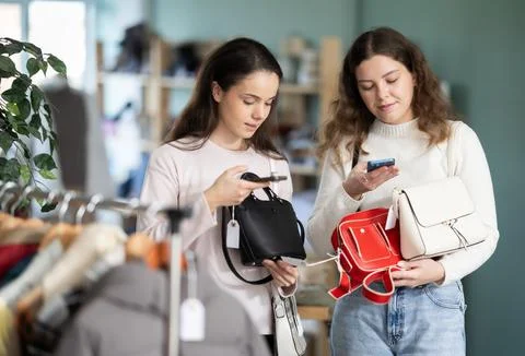 Young girls scanning QR-code on handbag in clothing store Stock-Fotos
