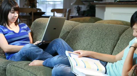 Young girls studying on sofa pan Stock Footage
