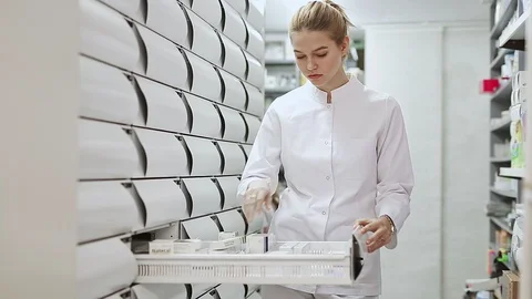 Young glad female customer searching for reliable drug in pharmacy Stock Footage