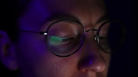 Young with glasses looking at the screen, reflection in the lenses of glasses Stock Footage 302809030