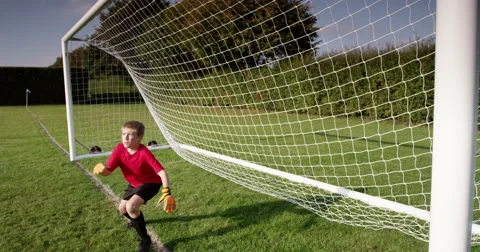 A young goal keeper fails to save a goal during a match in a soccer field. Video stock 56802799