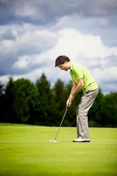 Young golf player putting. Stock Photos