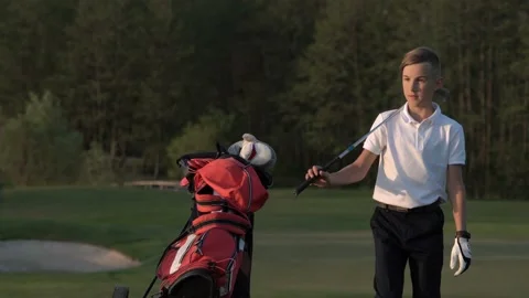 Young golfer fidgets while waiting to take his shot on the golf course Stock Footage 95121048