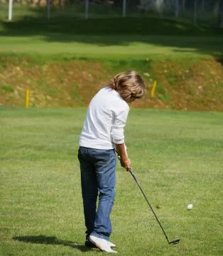 Young golfer performs a golf shot Stock Photos