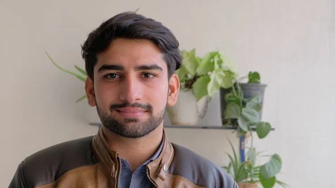 Young good looking Asian man looking straight at camera and smiling with confide Stock Footage 101286216