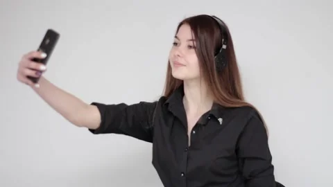 Young good looking girl posing in headphones taking selfie photo with smartphone Stock Footage 137540800