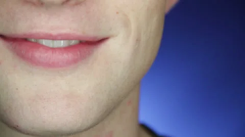 Young good-looking guy does amuse smile on a blue background Stock Footage 22848038