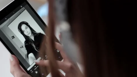 Young good looking lady editing black white photo on multi touch screen tablet Stock Footage 137541009