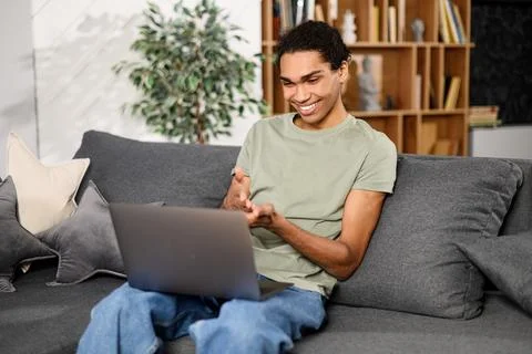 Young good-looking man is using a laptop for video connection, making real call Stock Photos