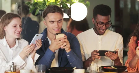 Young good looking people using their smartphones and smiling while spending Video stock 139884641