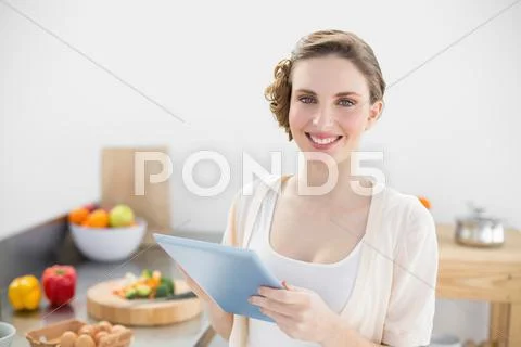 Young gorgeous woman using her tablet smiling at camera Stock Photos