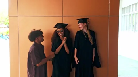 Young graduates dance joyfully in caps and gowns, celebrating their academic Video stock 326727074