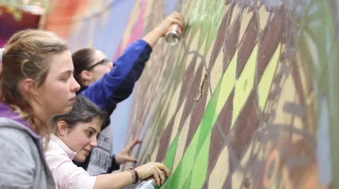 Young graffiti writers learning how to paint with colors on a wall 스톡 동영상 47148955