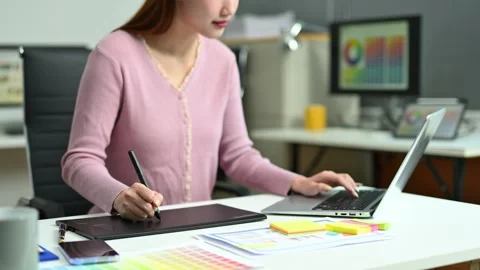 Young graphic designer using pen tablet and laptop at creative desk in mode.. Stock Footage 312436847