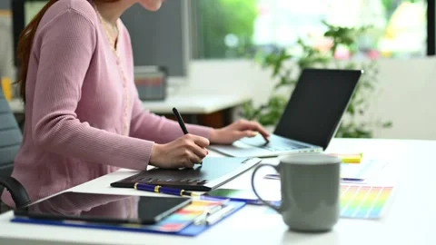 Young graphic designer using pen tablet and laptop at creative desk in mode.. Stock Footage 312436872