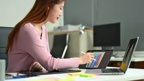 Young graphic designer using pen tablet and laptop at creative desk in mode.. Stock-Footage 312437019