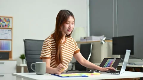 Young graphic designer using pen tablet and laptop at creative desk in mode.. Stock Footage 312437112