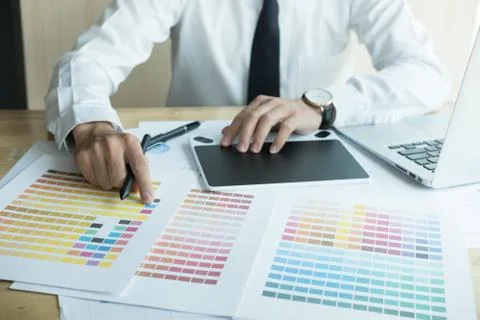 Young graphic designer working with computer and color swatch. creative man u Stock Photos