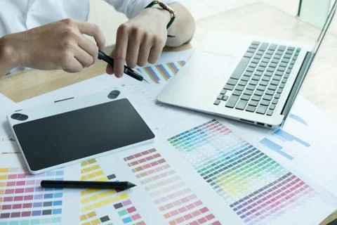 Young graphic designer working with computer and color swatch. creative man u Stock Photos