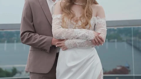 A young groom hugs his bride around the waist on their wedding day Video stock 329095053