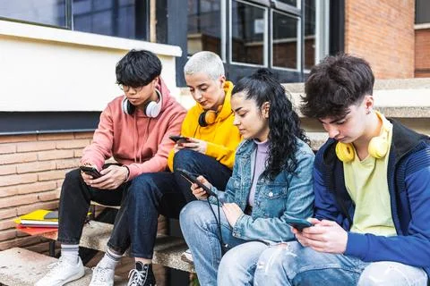 Young group of student friends using mobile smartphone at college campus Stock Photos