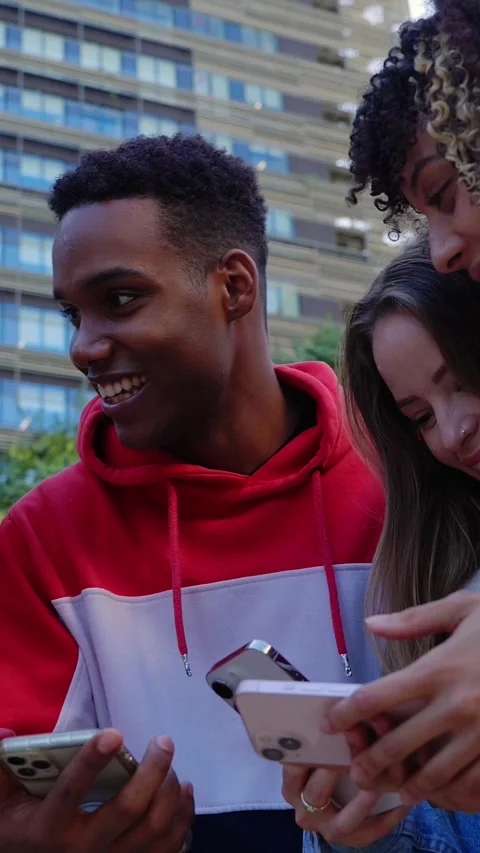 Young group of students using smartphone together outside Stock Footage 312198109