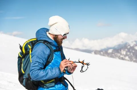 A young guide prepares crampons for use Stock Photos