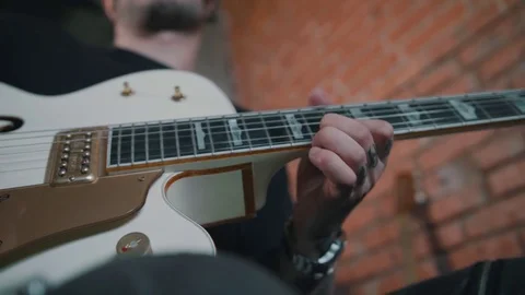Young guitarist, man with tattoos playing guitar solo, white guitar, low angl Stock Footage 80078053