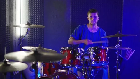 A young guy actively plays the drums in the studio Stock Footage 200226840