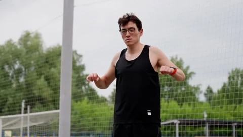 A young guy of Asian appearance is doing sports at the stadium, against the Stock Footage 255672156