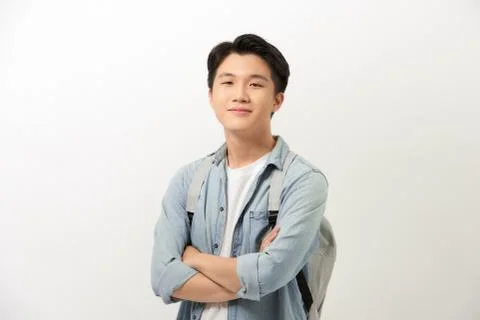 Young guy with a backpack standing with arms crossed isolated on white backgr Stock Photos