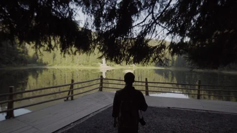 A young guy with a backpack, a tourist goes to a lake in the mountains Vídeo Stock 90092101