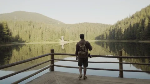 A young guy with a backpack, a tourist goes to a lake in the mountains Vídeo Stock 90093565