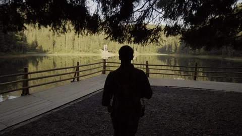 A young guy with a backpack, a tourist goes to a lake in the mountains Stock Footage 90094523